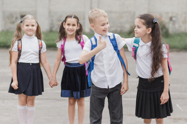 boy gesturing thumb up while standing near girl